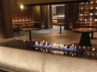 an indoor gas fire pit with a water feature in a casino VIP lounge