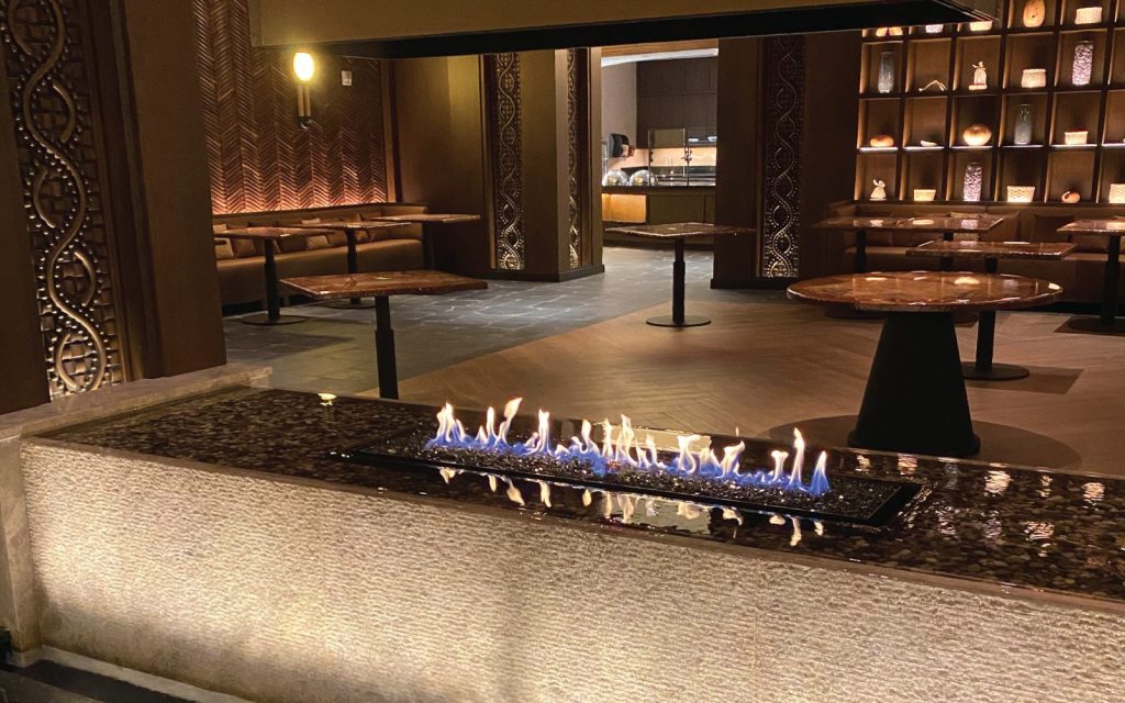 an indoor gas fire pit with a water feature in a casino VIP lounge