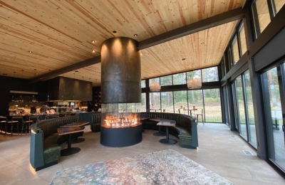 round gas fireplace with circular burner in restaurant with open floor plan