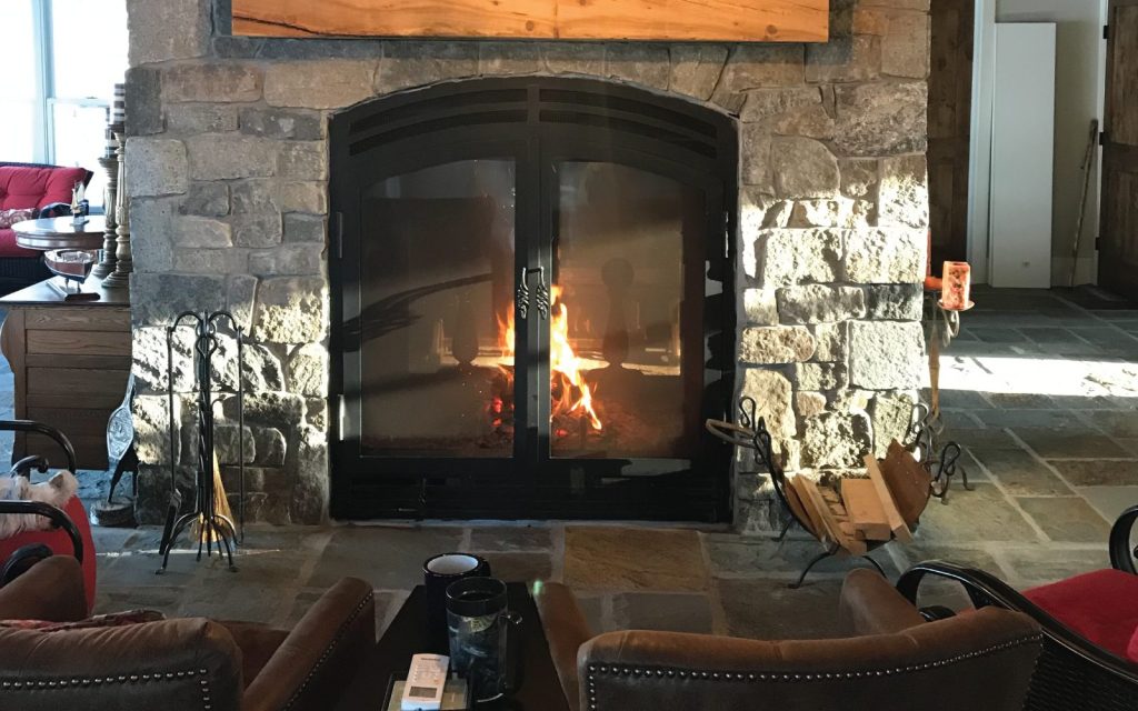 a very large two sided wood fireplace in a quaint cabin