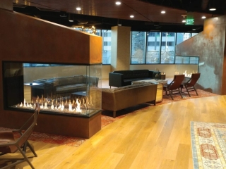 dual peninsula indoor gas fireplaces in office amenity lounge