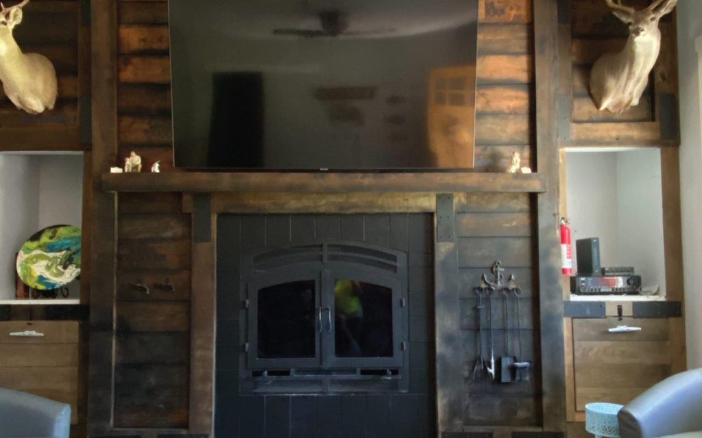 a modern wood burning fireplace with a tv above the fireplace