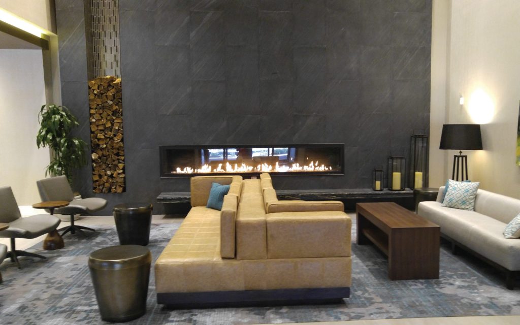 a long linear fireplace with wood stacked next to it
