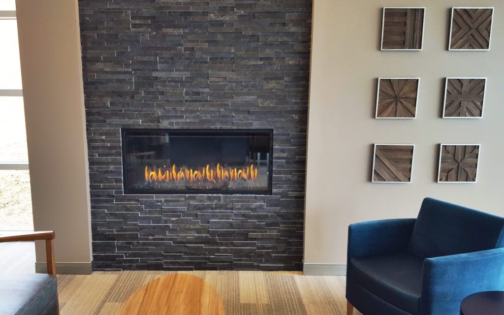 front facing gas fireplace with dark slate finish in medical center lobby