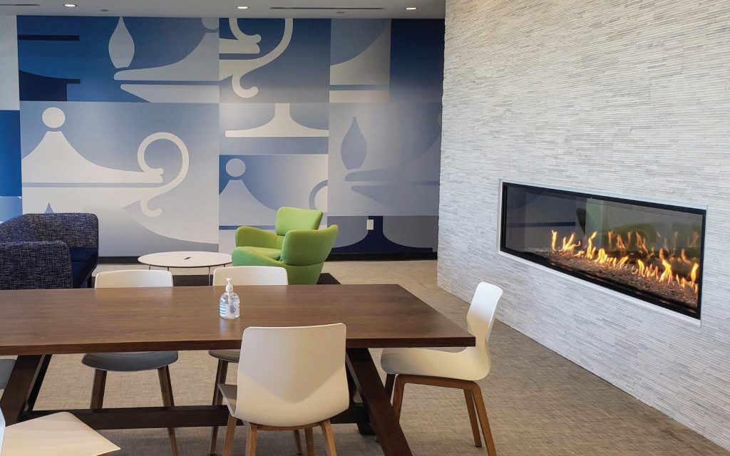 modern double sided gas fireplace with white finish in healthcare center space