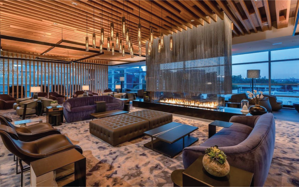 luxury airport lounge with dark furniture and ambiance with a grand glass fireplace