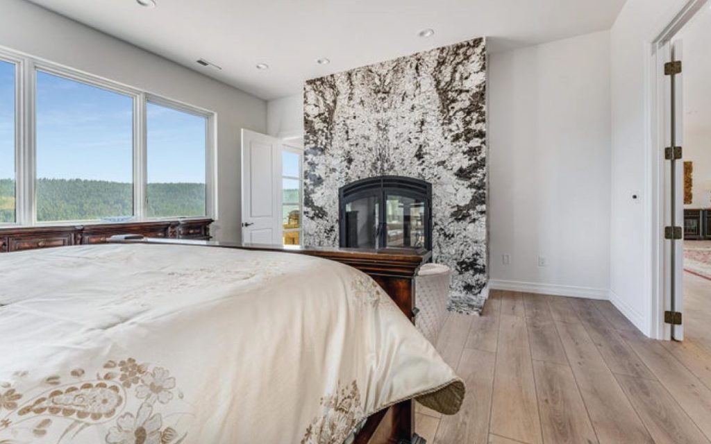 a large double sided wood burning fireplace in a master bedroom