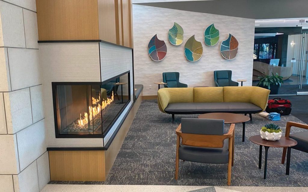 3 sided gas fireplace in colorful lobby space