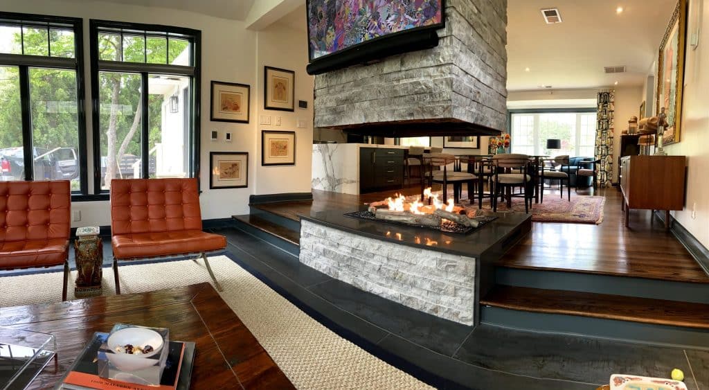 Modern living and dining area with a custom open four-sided indoor natural gas fire pit