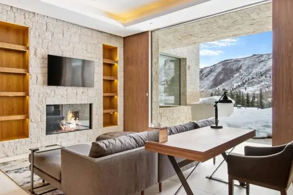 a cozy library reading room with a tv above a sealed gas fireplace