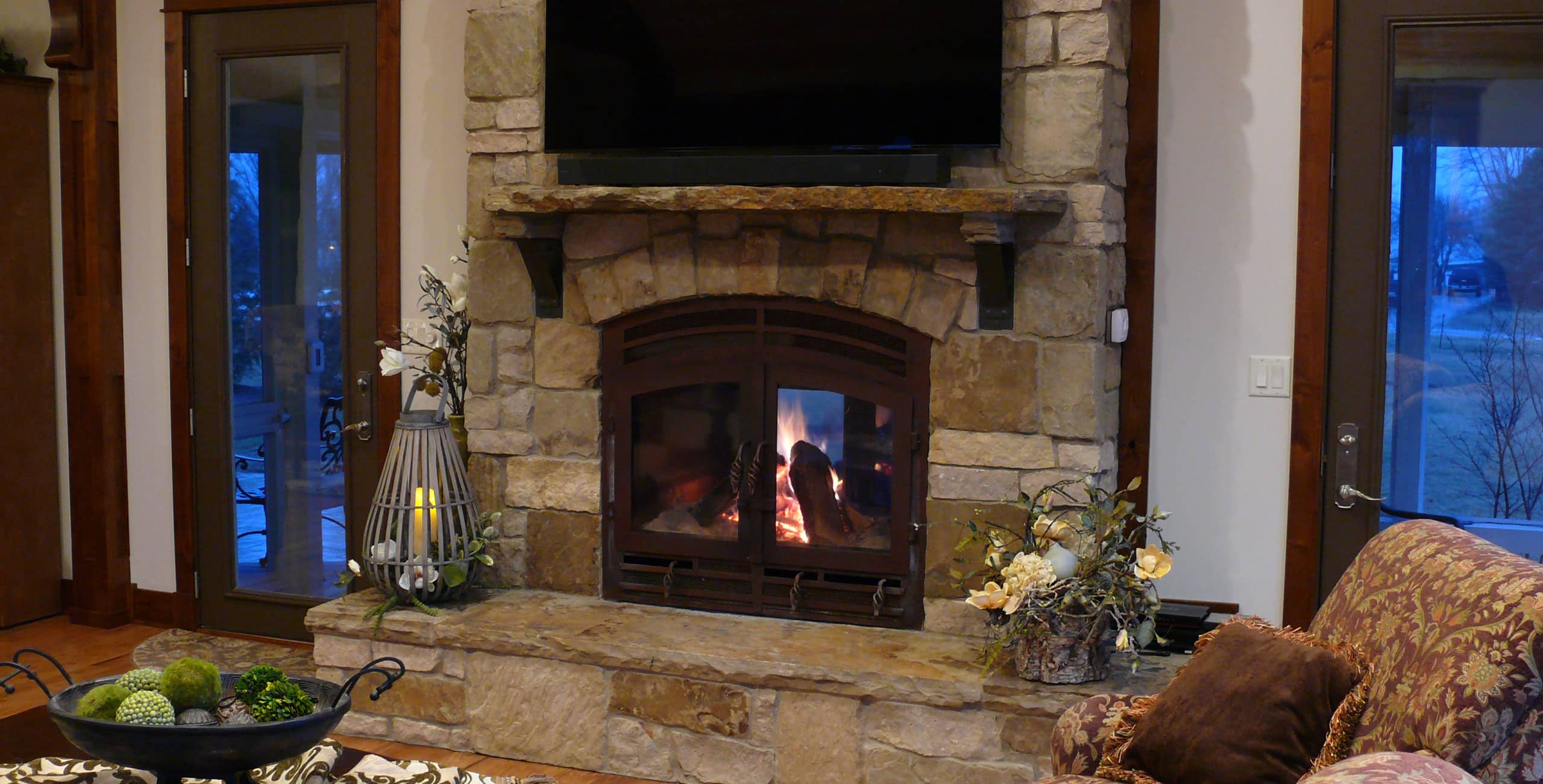 an image of a classic double sided wood-burning fireplace in a cozy rustic living room