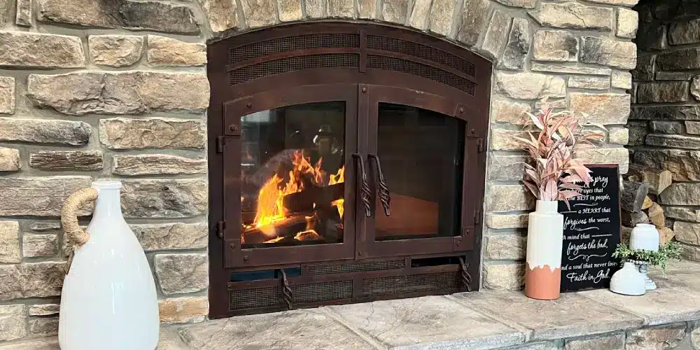 an image of a classic double sided wood burning fireplace with stone finish