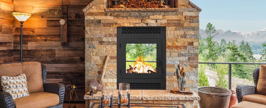 an image of a rustic cabin wood fireplace with two sides overlooking the wooded hillside
