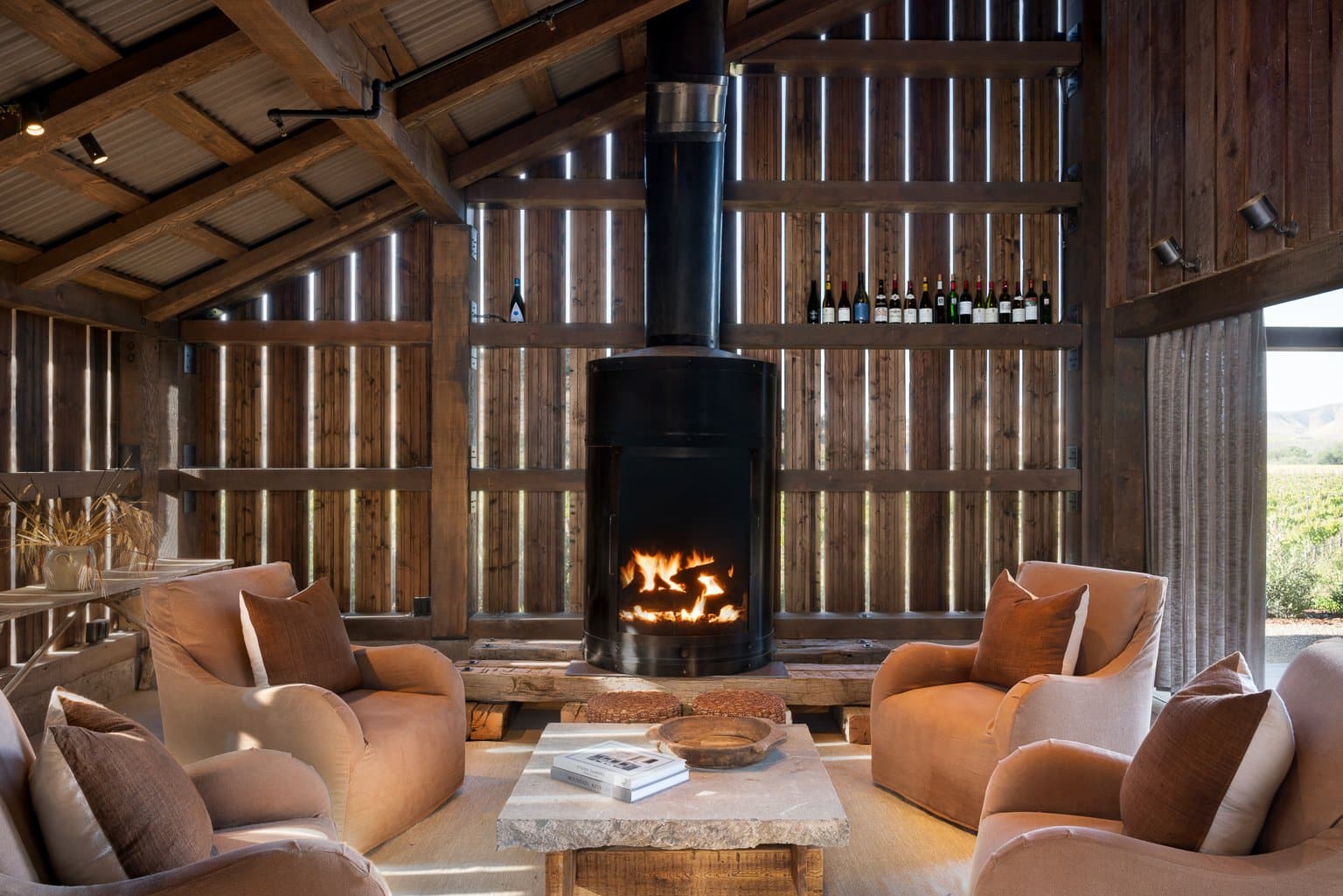A cozy rustic living space with a single-sided gas fireplace featuring a firescreen and logset.