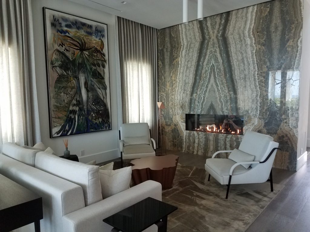 A contemporary see-through gas fireplace installed in a wall, offering a clear view of the flames from two adjoining rooms.