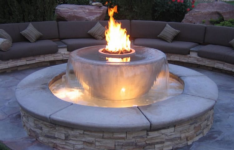 Acucraft custom outdoor burner seamlessly integrated into a fountain, showcasing endless customization options for adding a unique and luxurious fireplace to any patio.