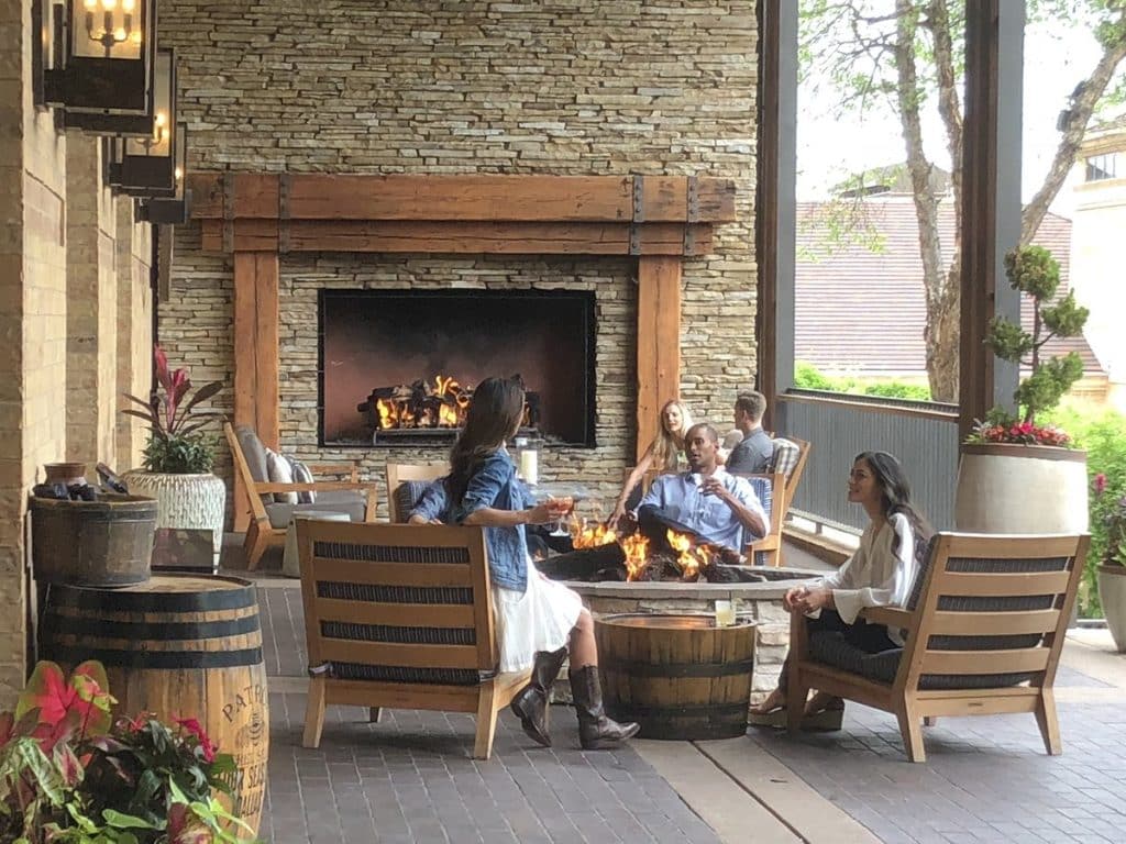 Acucraft custom outdoor gas fireplace with a sleek design, creating a warm and inviting patio space for entertaining guests while enhancing property value