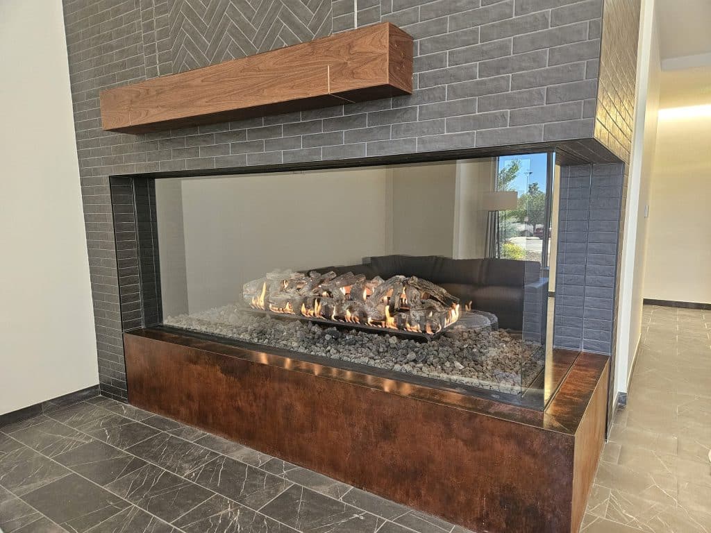 Sleek corner-view fireplace dividing living spaces with contemporary stone and glass design
