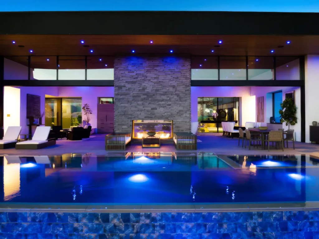 Acucraft custom indoor-outdoor gas fireplace connecting a covered patio and pool area
