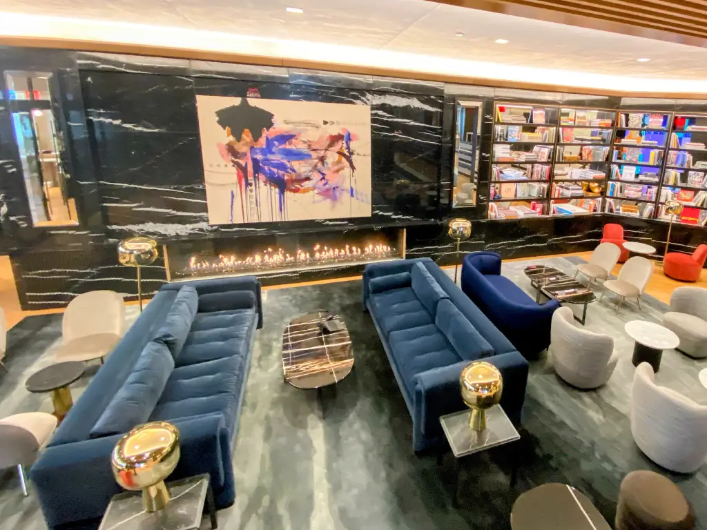 Acucraft custom linear single-sided gas fireplace in a black marble feature wall with artwork and shelving