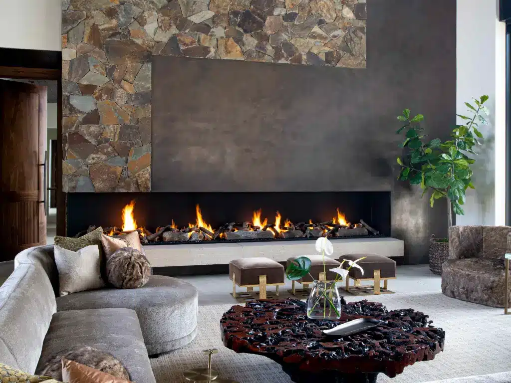 Acucraft custom open front-and-side-view gas fireplace in a stone and metal feature wall