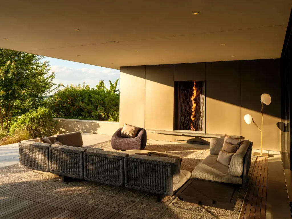 Acucraft custom outdoor gas fireplace with a vertical pole burner in a covered lounge