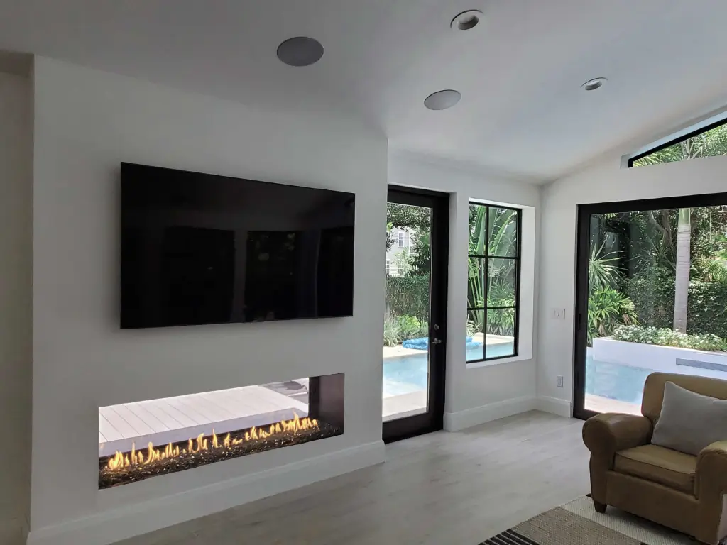 Acucraft Signature Series 6-foot indoor-outdoor linear gas fireplace beside patio doors
