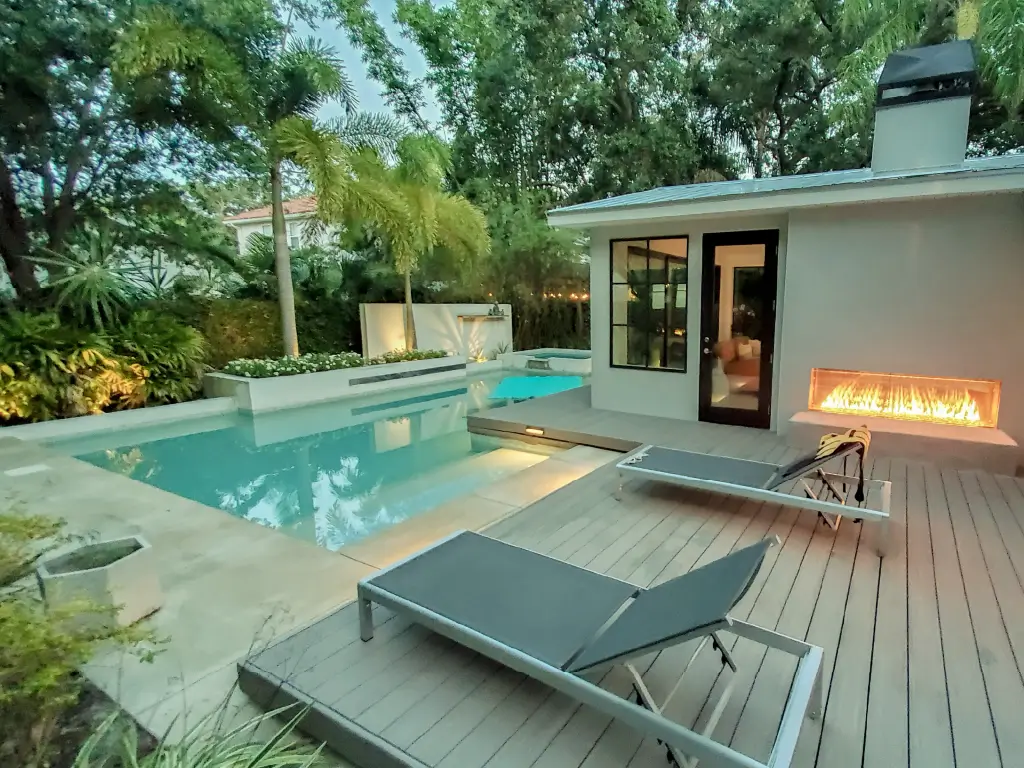 Acucraft Signature indoor-outdoor linear gas fireplace beside a luxury pool and patio