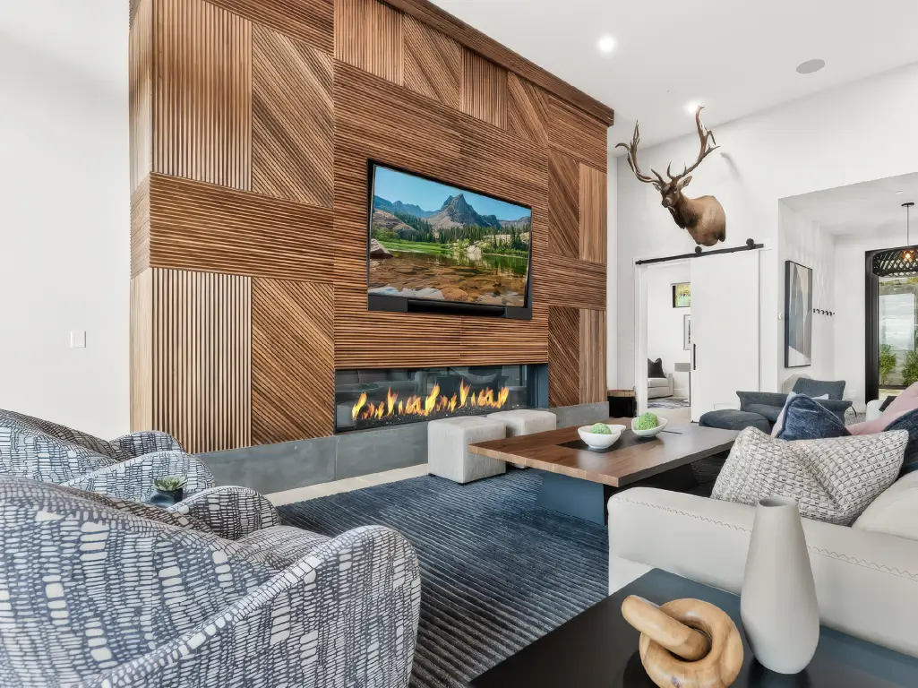 Acucraft Signature Series linear single-sided gas fireplace below a TV in a custom wood feature wall