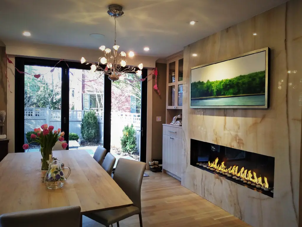 Acucraft Signature single-sided linear gas fireplace and TV integrated into a dining room wall