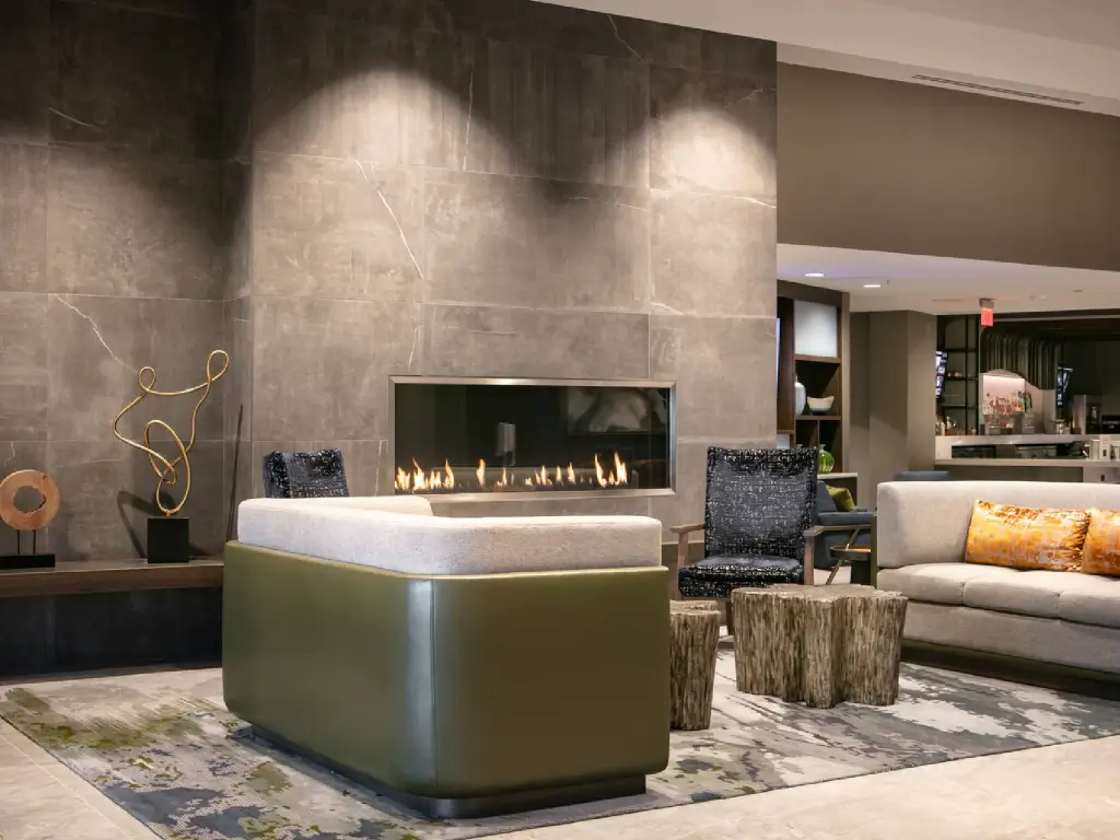 Acucraft BLAZE single-sided linear gas fireplace integrated into a tall stone feature wall