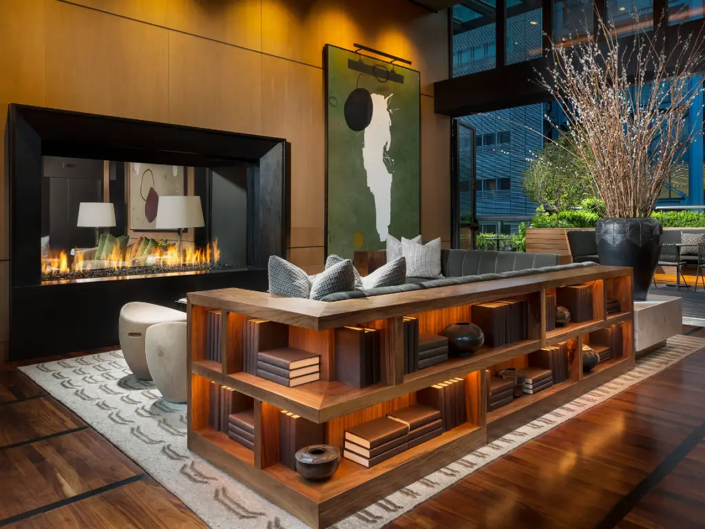 Tall linear Acucraft see-through gas fireplace connecting two seating areas