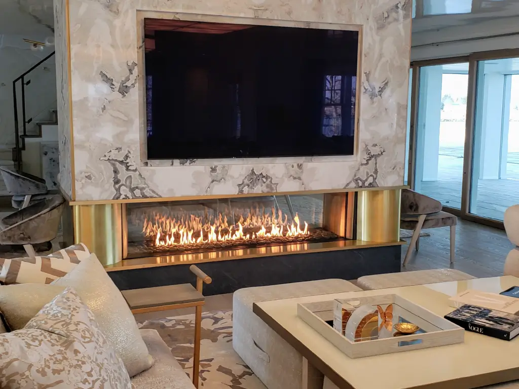 Acucraft custom linear see-through gas fireplace beneath a television in a luxury living room