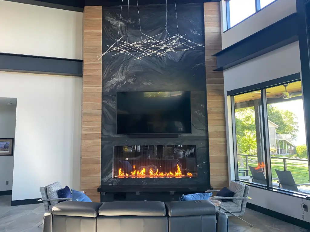 Acucraft custom single-sided linear gas fireplace in a tall modern feature wall