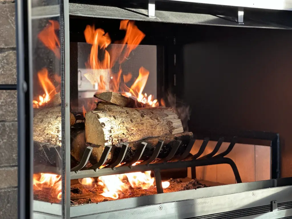 Burning logs inside an Acucraft Hearthroom 44 see-through wood fireplace