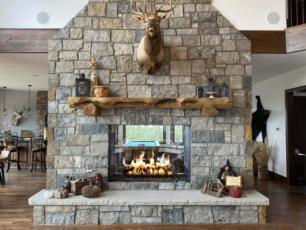Acucraft Timeless 36x36 see-through gas fireplace in a stone feature wall
