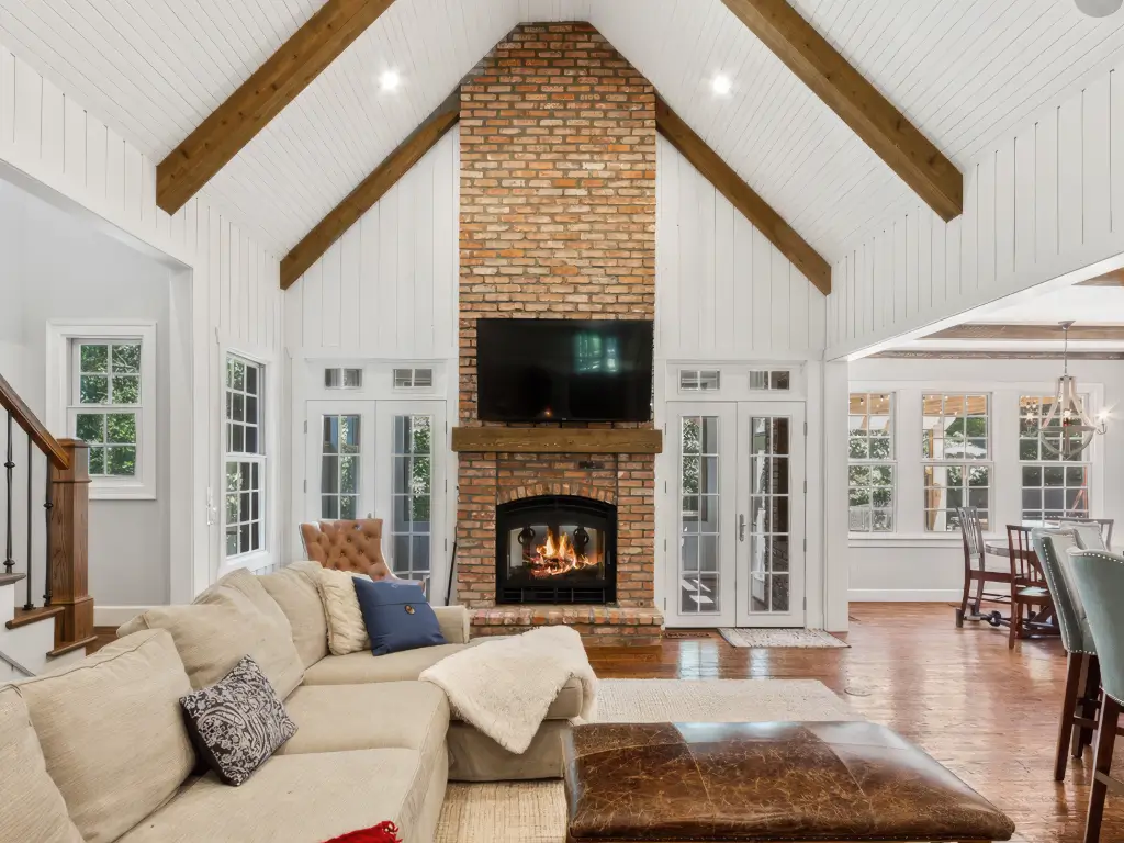 Acucraft wood fireplace in a vaulted white great room with adjacent dining area
