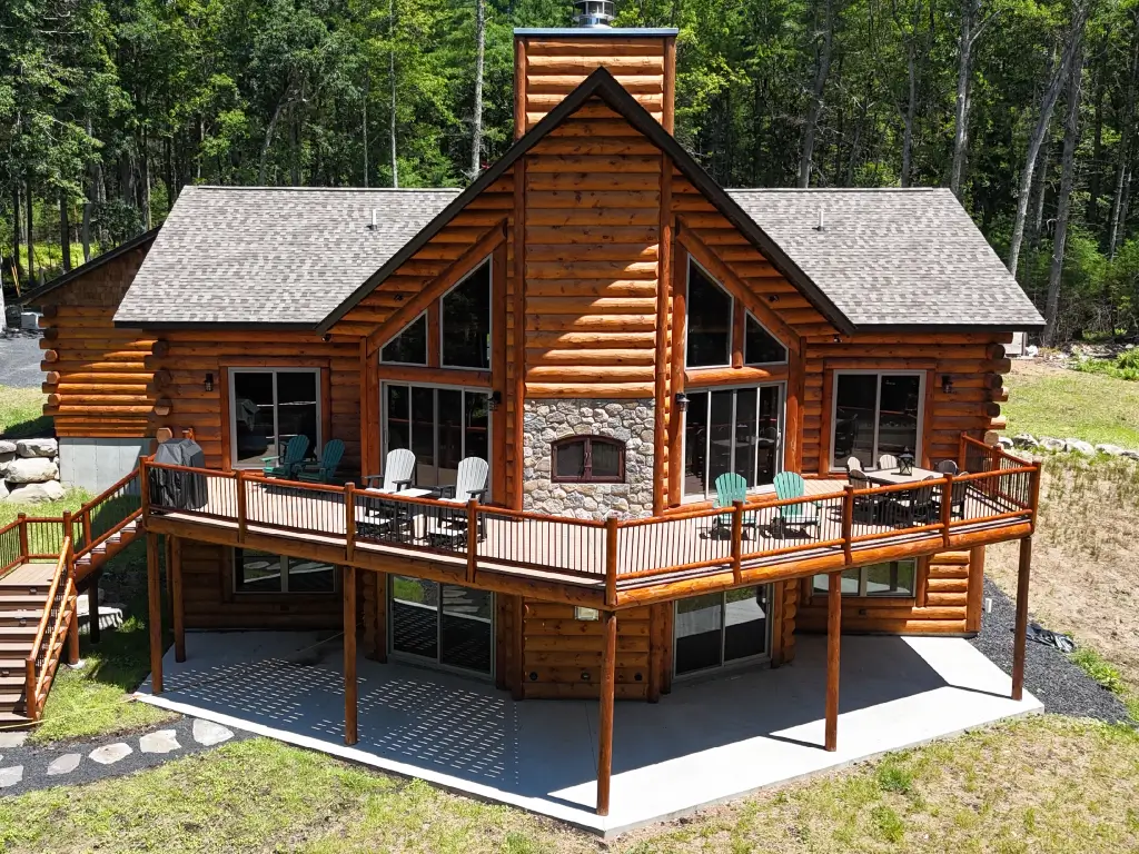 Timber retreat home with Acucraft indoor-outdoor wood fireplace and wraparound deck