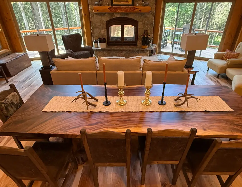 Dining and living spaces arranged around an Acucraft wood fireplace in a timber lodge