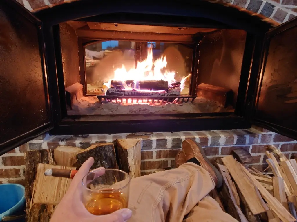 View of a burning fire from the hearth of an Acucraft Hearthroom 44 indoor-outdoor wood fireplace.
