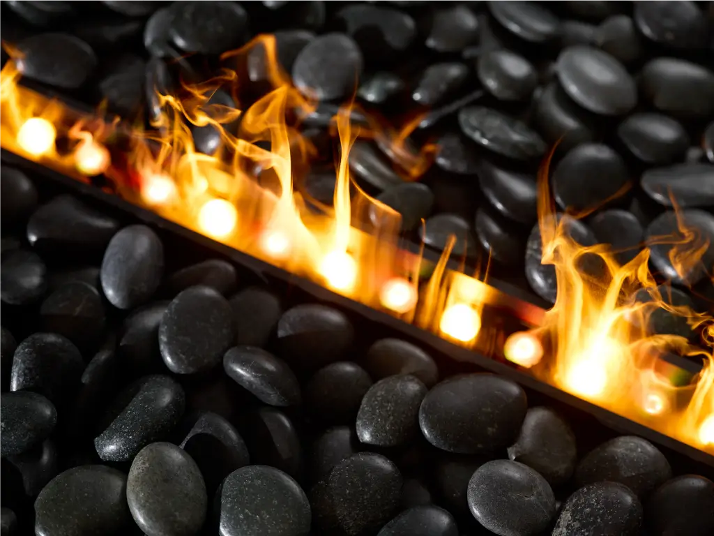 Close-up of water vapor flames and black fireplace media stones.